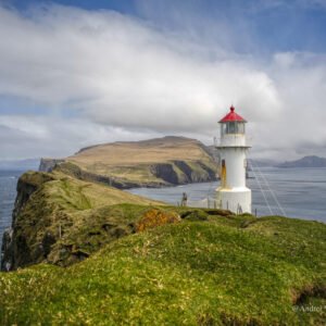 Image of Mykines Holmur, the lighthouse standing in front and Mykines in the background