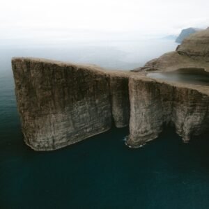 Lake above the ocean., vágar, faroe islands. Tall cliff on by the ocean, with a lake above the ocean