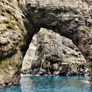 Natural rock arch above the sea at the dramatic Vestmanna Bird Cliffs in the Faroe Islands