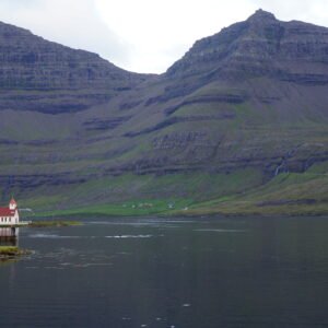 Viðareiði church by the sea beneath steep mountains on Viðoy in the Faroe Islands