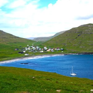 Coastal village of Húsavík surrounded by green hills and a sheltered bay on Sandoy, Faroe Islands