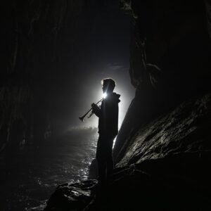 Trumpet player performing inside a dramatic sea cave during a cave concert in the Faroe Islands